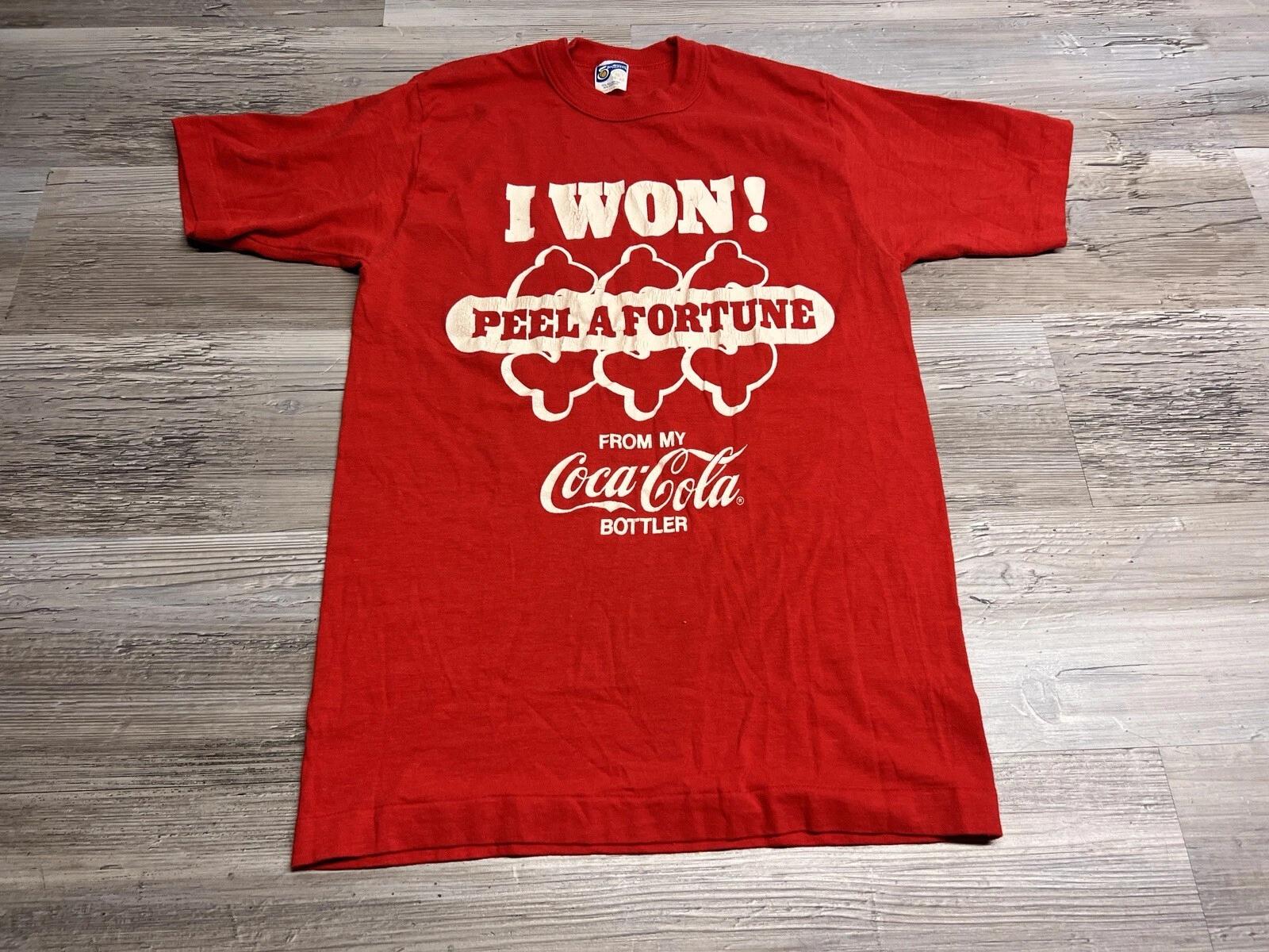 Vintage 80s Coca Cola Promo T-Shirt I Won Peel A Fortune Coke Is It! Size M USA L
Vintage 80s Coca Cola Promo T-Shirt I Won Peel A Fortune Coke Is It! Size M USA L