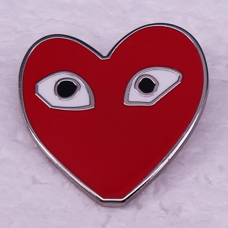 Comme des Garçons Heart-Eyes Logo Brooch
Comme des Garçons Heart-Eyes Logo Brooch