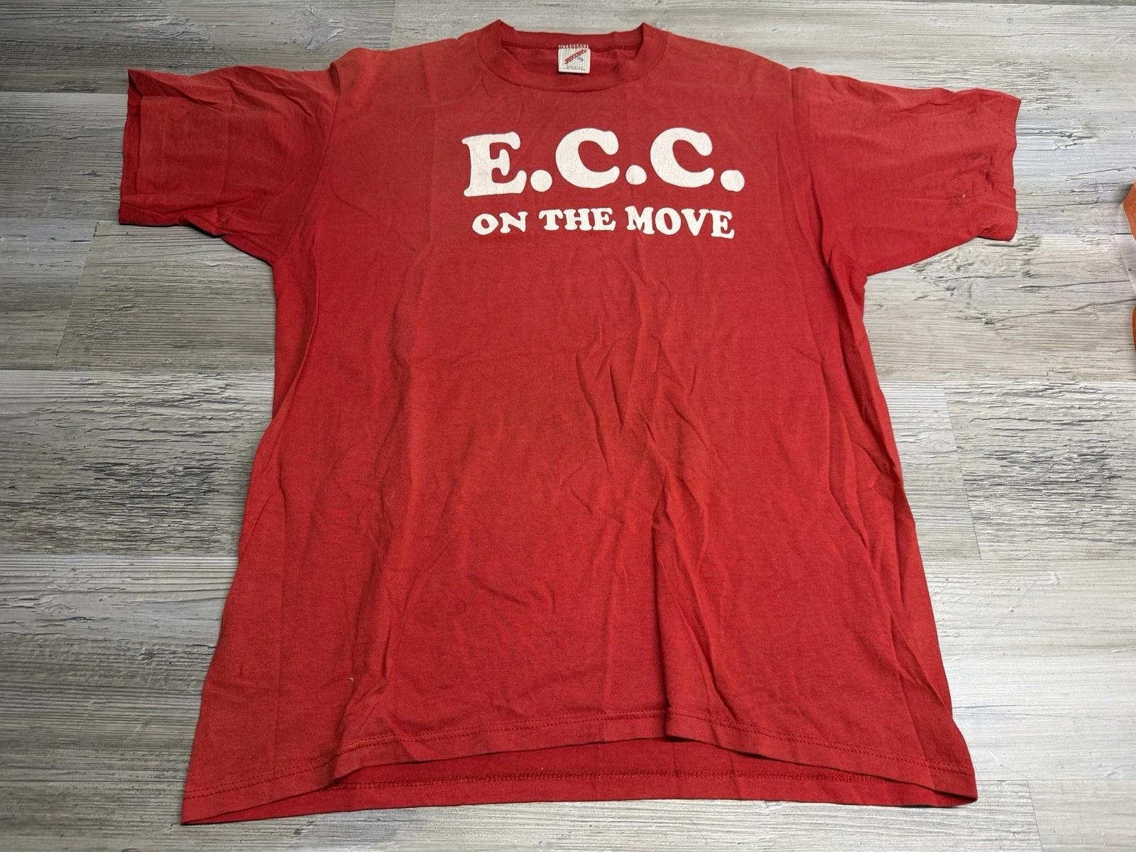 Vintage 90s Graphic T-Shirt Single Stitch Corporate Slogan ECC On the Move Sz XL 4XL
Vintage 90s Graphic T-Shirt Single Stitch Corporate Slogan ECC On the Move Sz XL 4XL