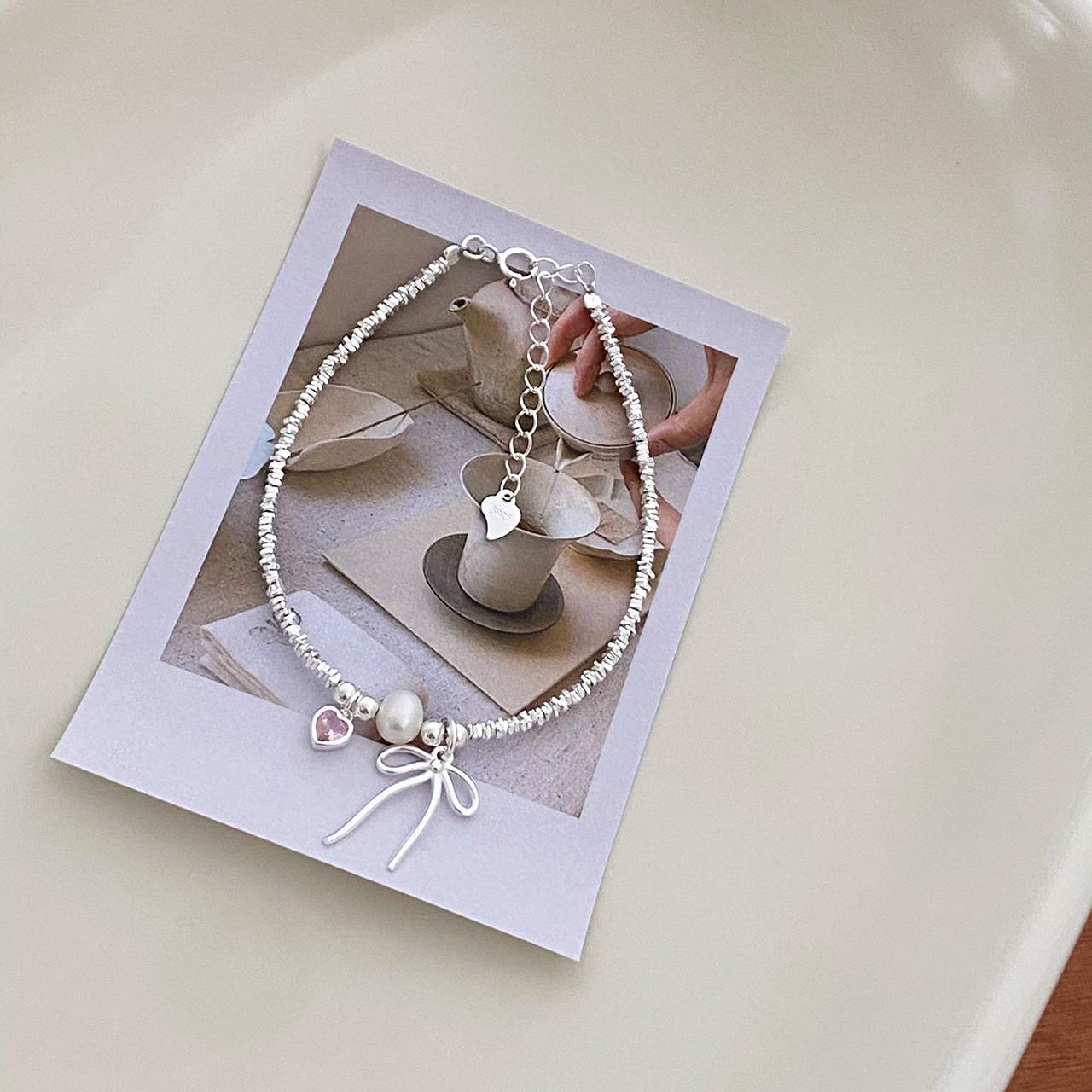 Срібний браслет 925 проби з рожевим серцем, бантом та перлами для жінок
Срібний браслет 925 проби з рожевим серцем, бантом та перлами для жінок