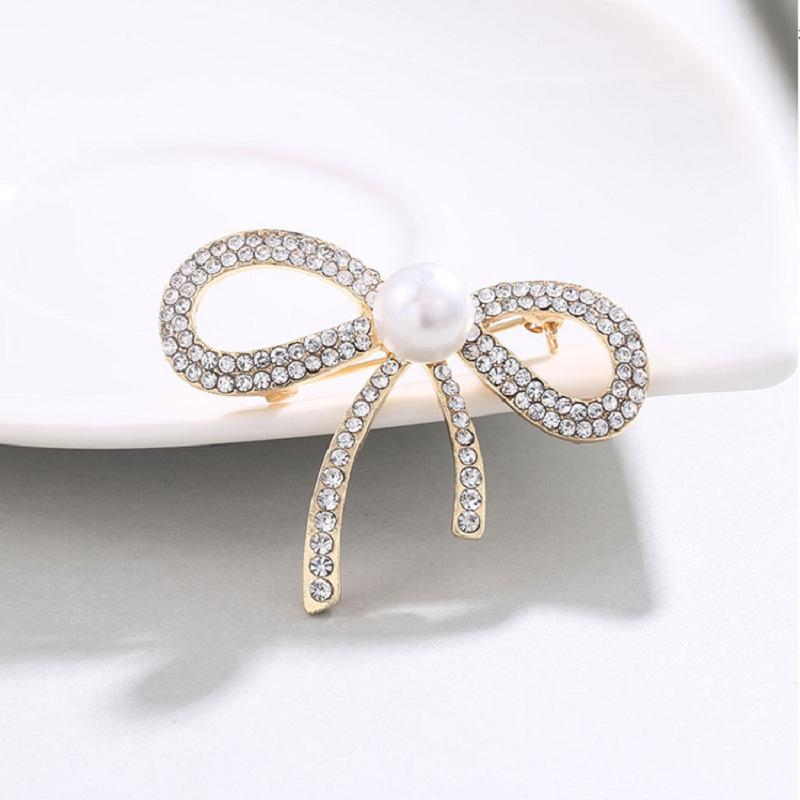 Хит продаж Белый жемчуг Бант с бриллиантовой брошью с бриллиантом, Высококачественная корсажная брошь для одежды, Универсальная ювелирная булавка для одежды золотой
Хит продаж Белый жемчуг Бант с бриллиантовой брошью с бриллиантом, Высококачественная корсажная брошь для одежды, Универсальная ювелирная булавка для одежды золотой