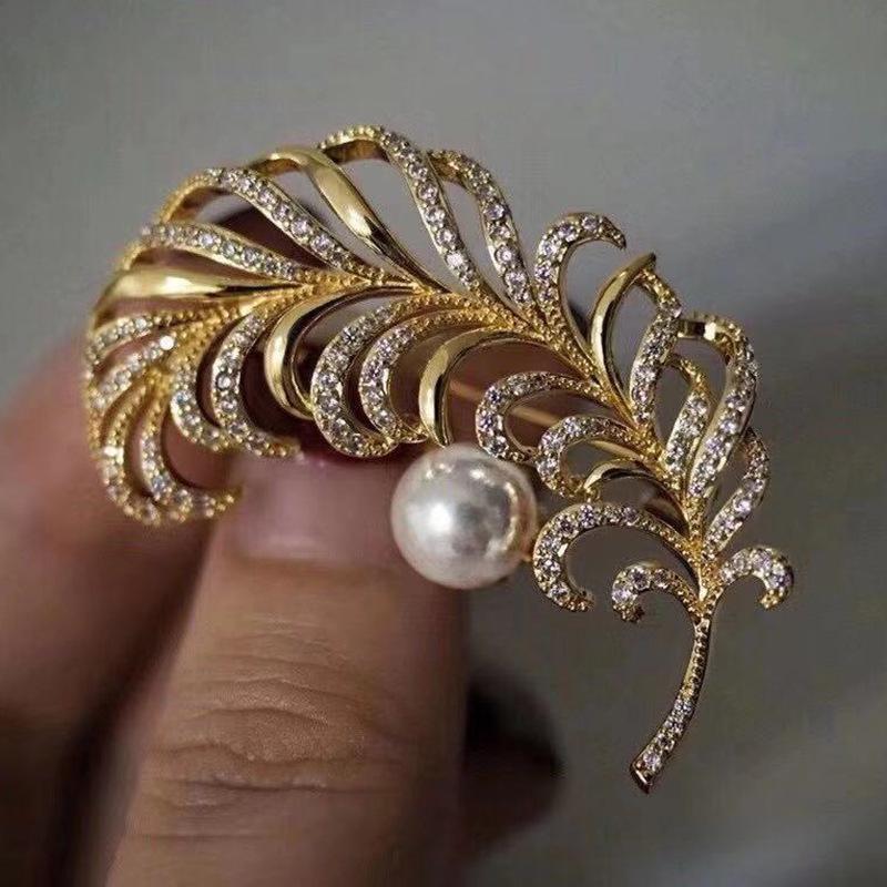 Позолоченная брошь-перо с цирконами и жемчужной отделкой
Позолоченная брошь-перо с цирконами и жемчужной отделкой
