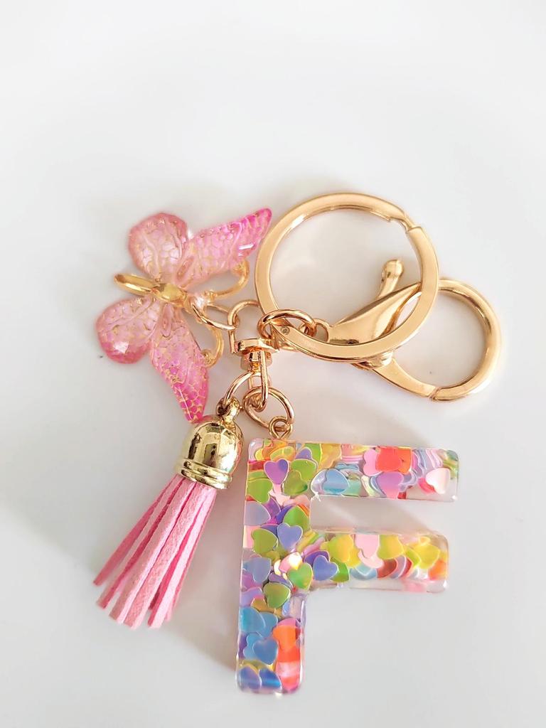 Rosa Glitzer Epoxidharz Schlüsselanhänger mit englischem Buchstaben und Schmetterlingsquaste