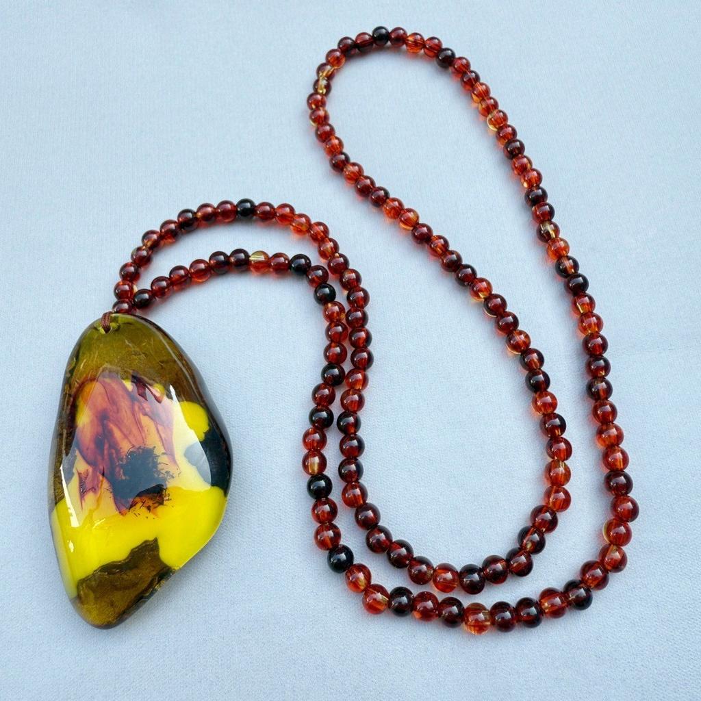  Bursztynowy Vintage Bursztynowy Wisiorek Naszyjnik Wiszący Dla Mężczyzn I Kobiet Z Krwistoczerwonymi Perłami. Naszyjnik Spokojny Urok na Łańcuszku w Etnicznym Swetrze.