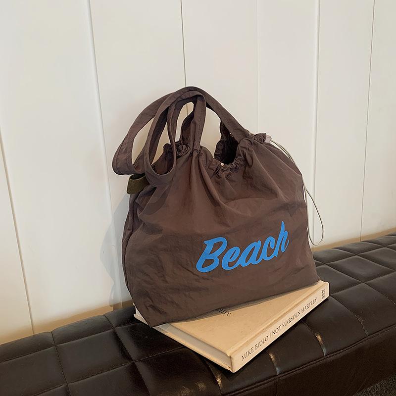 

Корейская версия сумки с буквенным принтом, женская сумка 2024 года, большая вместительная нейлоновая сумка через плечо, повседневная универсальная сумка-тоут со шнурком