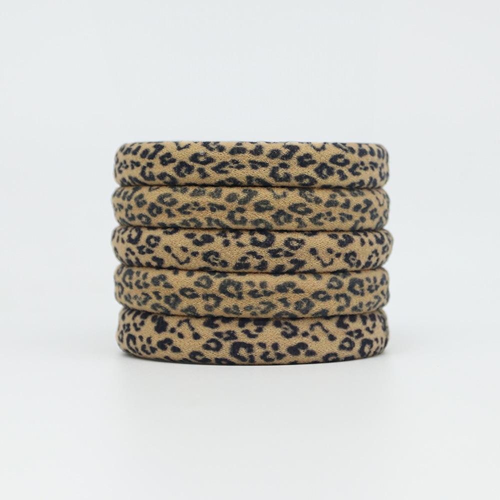Ein Damen-Haargummi mit einem Handtuch-Haargummi mit Leopardenmuster und einem Zopfgummi schädigt das Haar nicht