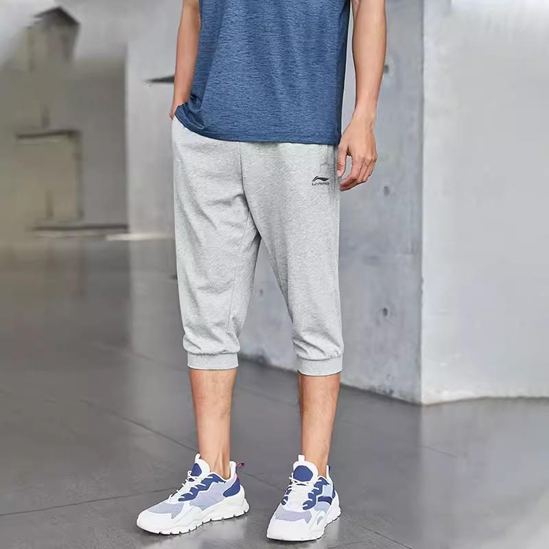 Li Ning Sports Lifestyle Series Solid Color Mid Waist Comfortable Versatile Breathable Tapered Three Quarter Knitted Sports Pants Men Pants AKQU431-2