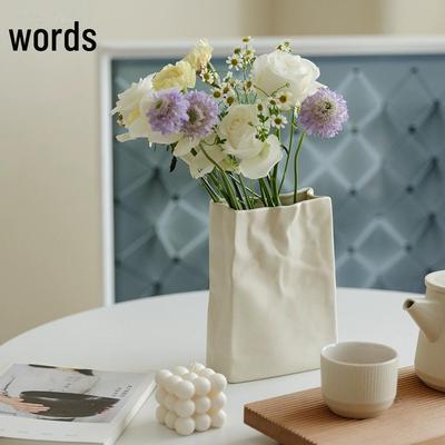Luxuriöse weiße Keramikvase zur Dekoration von Wohnzimmer und Schlafzimmer mit Origami-inspiriertem Design und hochwertigen Details.