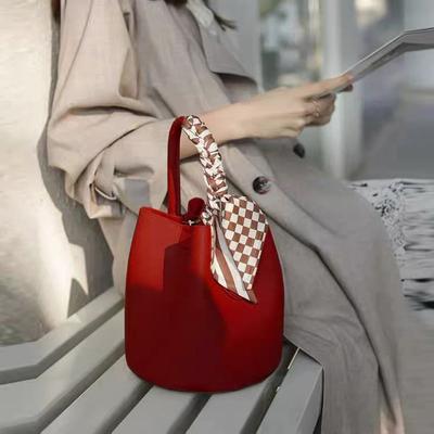 Questa borsa a secchiello di grande capacità presenta un design di nicchia.. È una borsa rossa da matrimonio per spose ed è versatile per le donne in estate