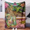 A Blanket Featuring a Leopard On a Chair Surrounded by Flowers And Plants. Made from Soft Flannel Material It Has Digital Prints I