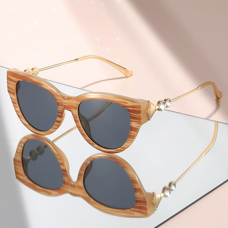 New cat-eye sunglasses with diamond-like embellishments on metal temples for a high-end versatile look