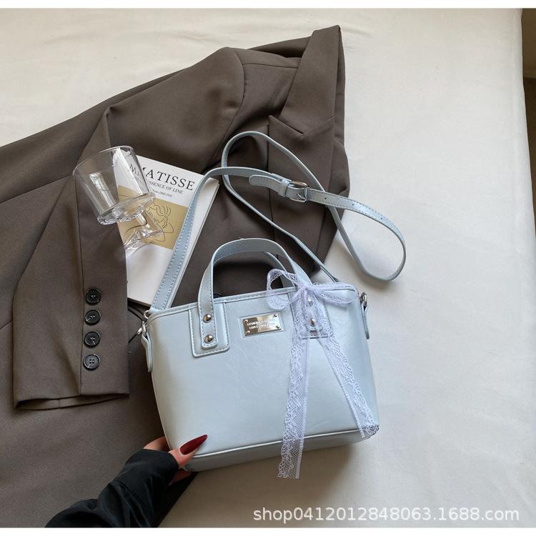 

В этом году популярна корейская версия нишевой простой портативной сумки-ведра, а также высококачественная кожа с масляной восковой пропиткой, подходящая для通勤 и универсальная в качестве сумки через плечо.