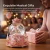 Snow globe music box with colored LED lights, merry-go-round, crystal ball, and automatic snowfall. Popular as a birthday or Christmas gift for girls,