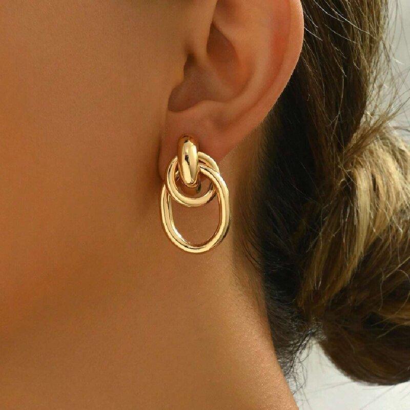 Ein Paar vergoldete gekreuzte Eisenrohr-Creolen, minimalistische und raffinierte Doppel-Creolen für Damen, geeignet für