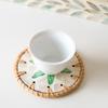 The hand - made rattan - edged shell coasters add a unique marine style to the tabletop.
