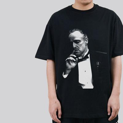 Eine Vintage-Straße von Der Pate Corleone, mit einem lässigen schwarzen Kurzarm-Mann mit Rundhalsausschnitt und einem Vintage-Stil