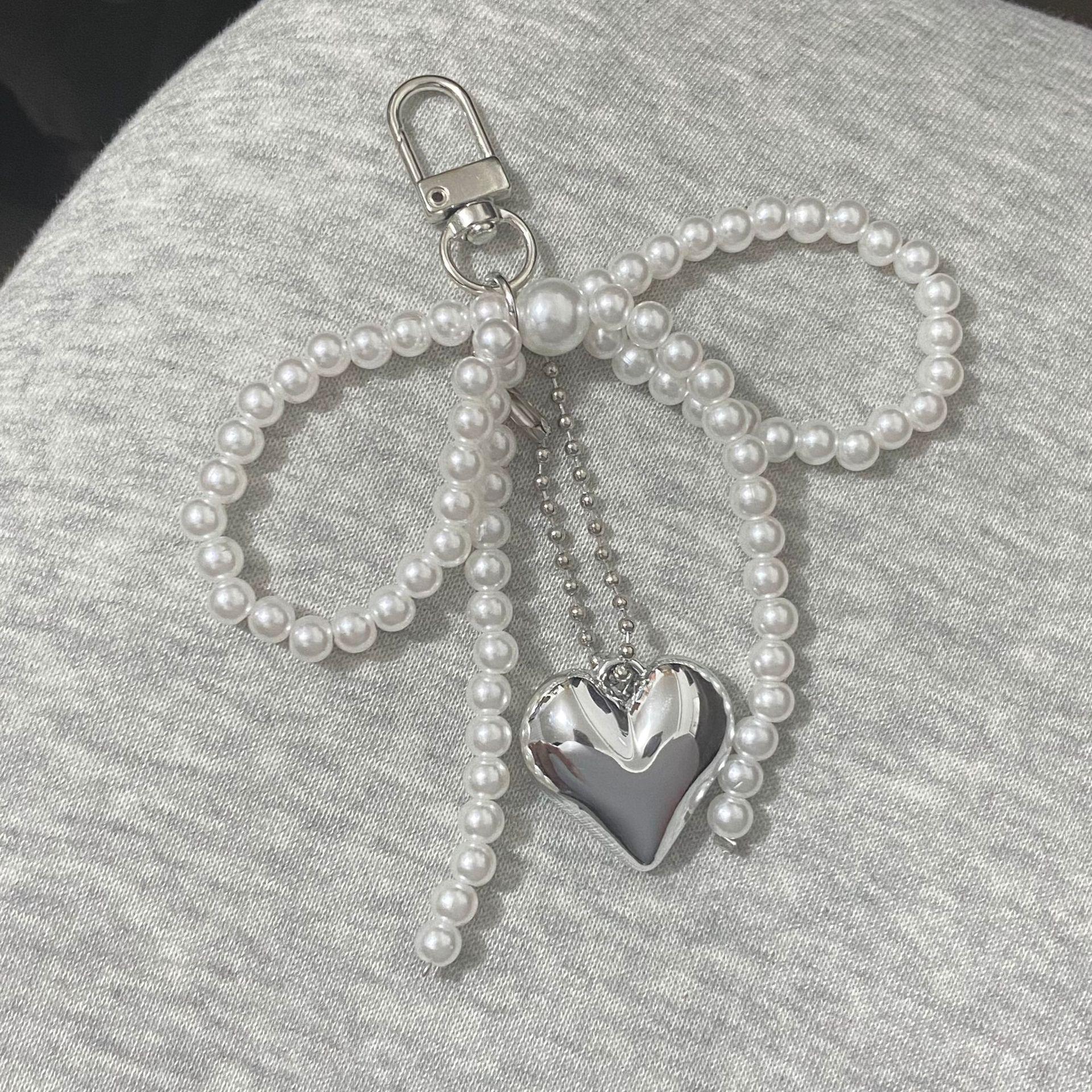 

Стильний брелок з підвіскою у вигляді перлинного банта та серця - Унікальний DIY аксесуар для сумки