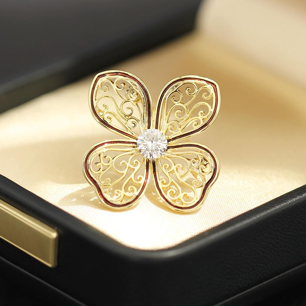 

Temperament niche hollow pattern dripping oil two-color flower brooch small and exquisite versatile anti-light pin accessories women
