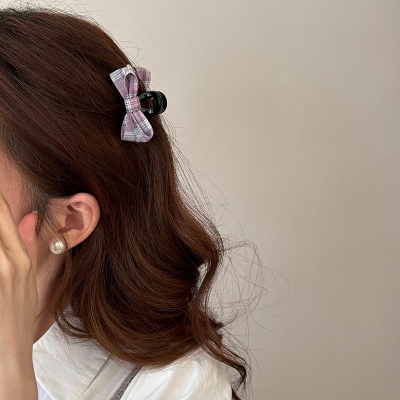 The Princess with The Checkered Bow Accessory Has A Chic Patterned Beak Hairpin At The Back of Her Head and A Hairclip.