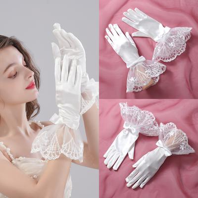 Ein Paar weiße Fingerhandschuhe, geeignet als Accessoires für Brauthochzeiten oder Frauentänze