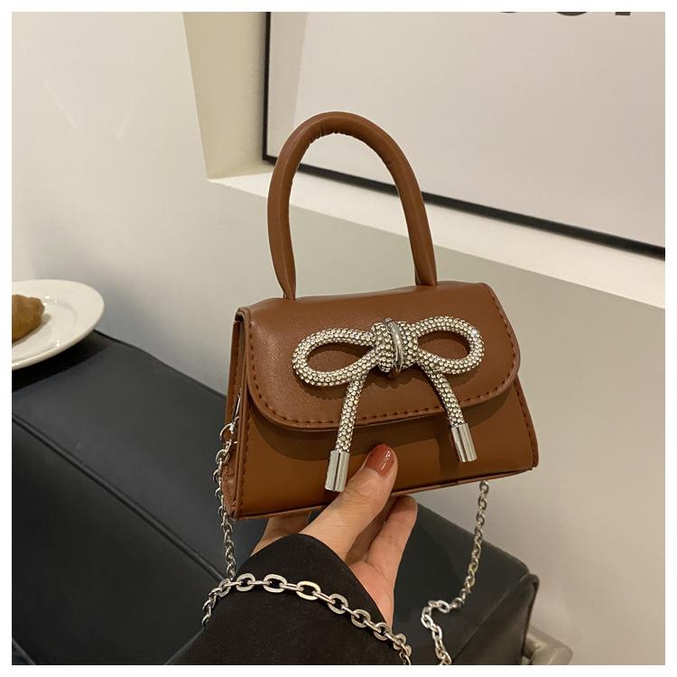 

Жіночий зарубіжний стиль із цукерковим бантом популярний цього року, лакована глянцева сумка-месенджер, сумка через плече, персоналізована сумка з діамантами. темно-коричневого кольору