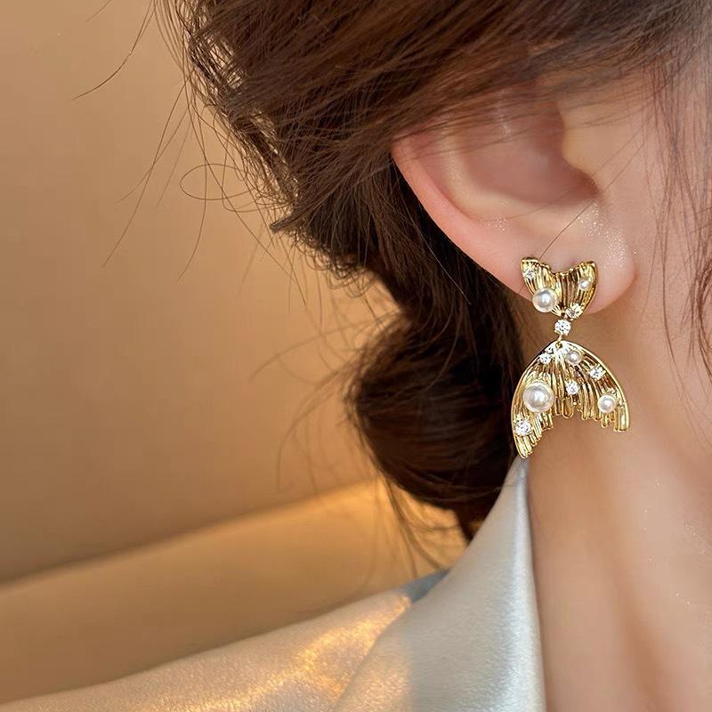 Gold fishtail pearl ear clips without ear piercings, high-end sense niche unique earrings, long mosquito coil disc earrings.
