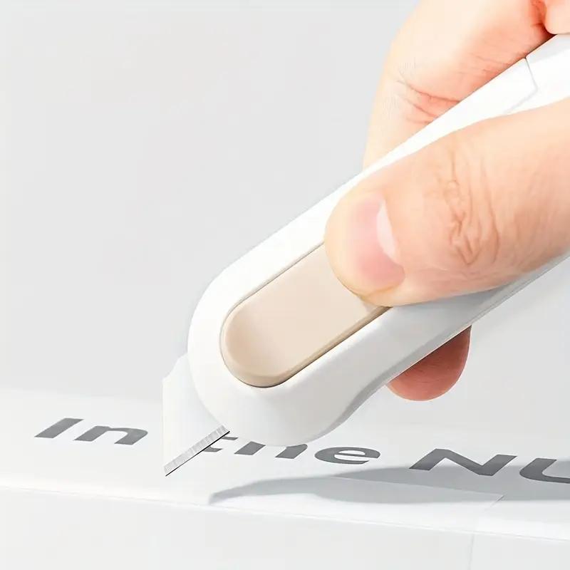 Canivete retrátil automático compacto e portátil equipado com lâmina afiada e durável. Ideal para artesanato, abertura de caixas e uso em escritório