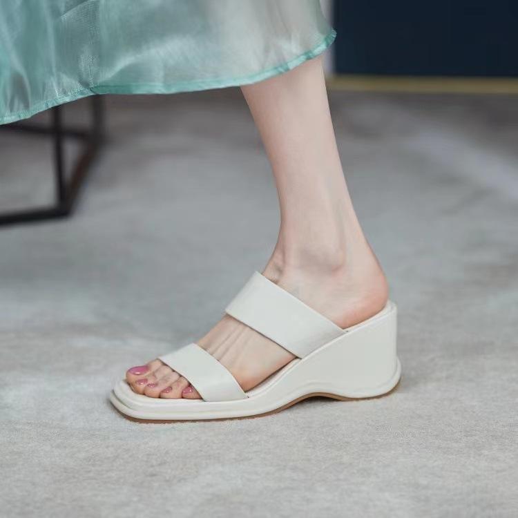 In the summer of 2025, the new thick-soled muffin sandals for women wear one-word cool slippers with a high heel and a half drag.