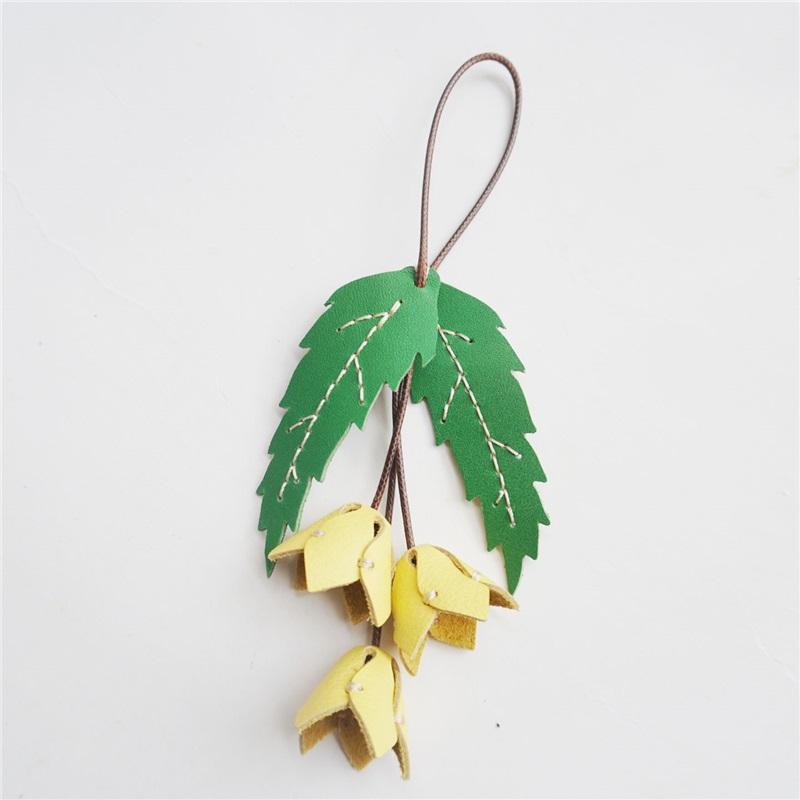 

Декоративный брелок из натуральной кожи ручной работы с маленькой желтой подвеской-цветком жёлтый