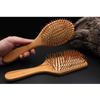 Natural wood paddle comb with bamboo bristles to detangle hair, suitable for women, men, and children, reduces frizz and massages the scalp