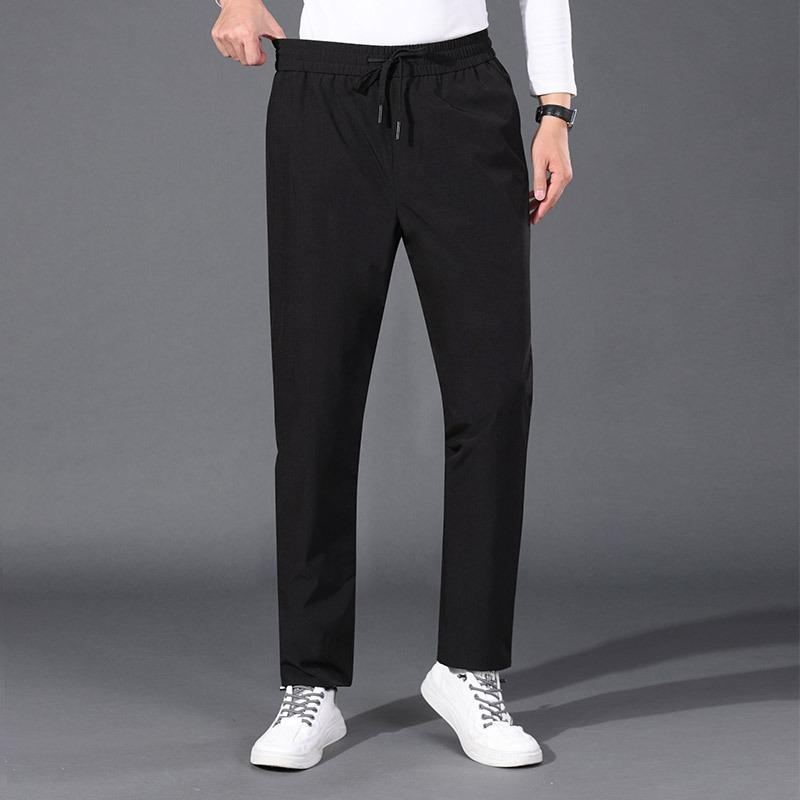Papa porte un pantalon d'hiver en duvet et porte un pantalon thermique de sport business casual à taille haute. Pantalon en duvet d'oie droit pour hommes d'âge mûr