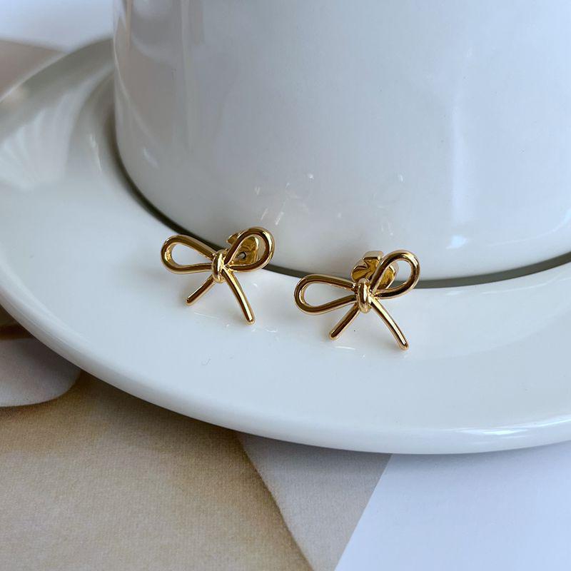 

Trendy Minimalist Bow Earrings: Glossy Metal Design for a Slimmer Look золотой