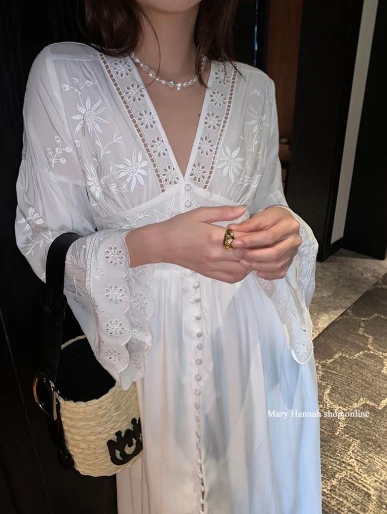 Robe blanche à manches longues et broderie ajourée pour les vacances à l'île ou à la plage