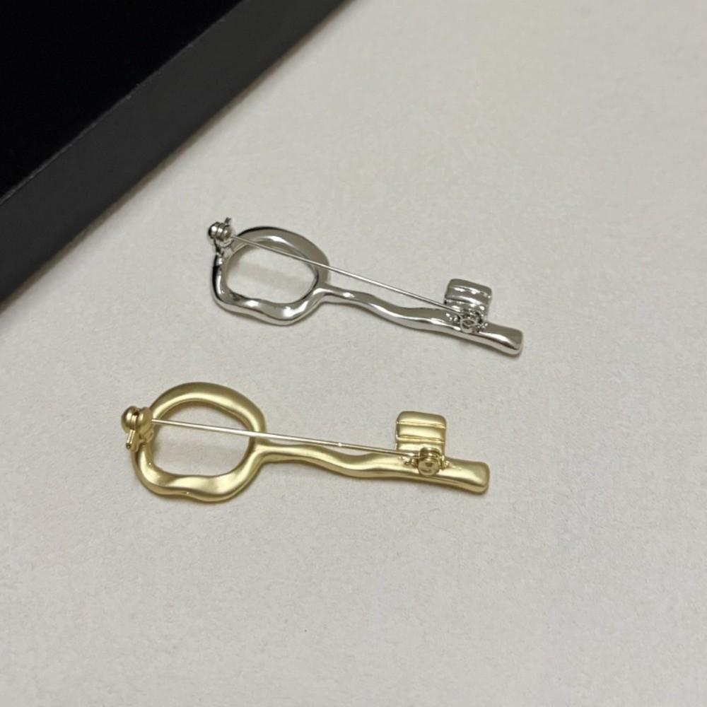 Spilla a forma di chiave in lega di zinco Design con foro per serratura Spilla decorativa in metallo Accessorio per abito Cappotto Decorazione per abbigliamento