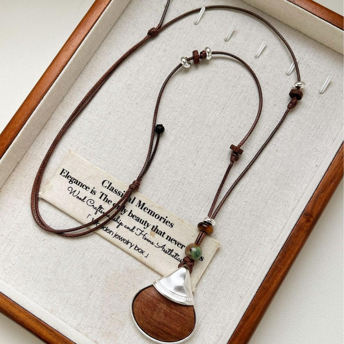 

Vintage fan-shaped wooden pendant necklace with adjustable drawstring. темно-коричневого кольору