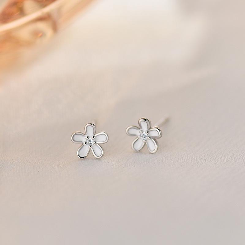 

Серьги-цветы маленькие и элегантные, а женская текстура изысканная и свежая