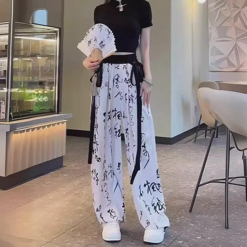 Elegantní kalhoty se širokými nohavicemi z ledového hedvábí s čínskou kaligrafií - Dámské letní ležérní splývavé