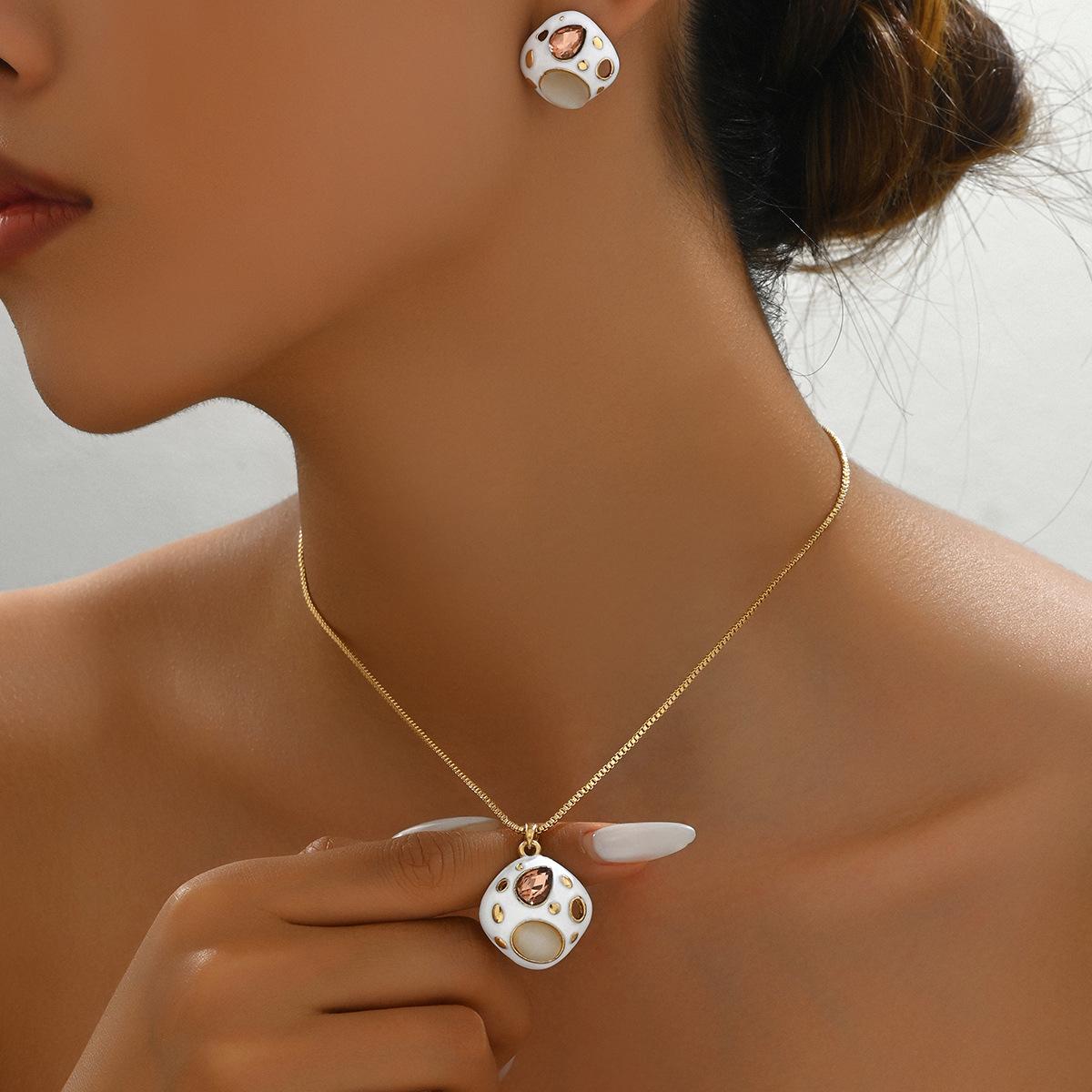 

Простой набор колье и серег с драгоценным камнем, геометрическим дизайном и цепочкой для ключицы.