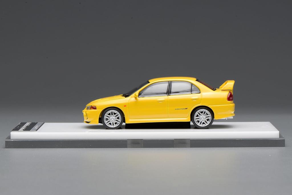 FREESTYLE MOTORHELIX Mitsubishi Lancer Evolution IV Dandelion Yellow Finished Model M64007 1/64