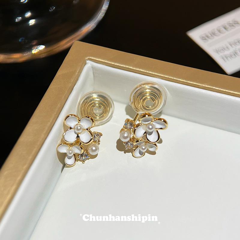 

White mini flower ear clips without ear piercings, high-end niche design stud earrings, women s small and exquisite mosquito coil disc earrings.