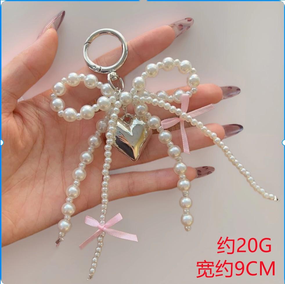 

Pearl Bow Bag Charm with Integrated Ring Branch Design Featuring Bow and Central Heart Pendant Suitable for Various Handbags and Accessories One Size