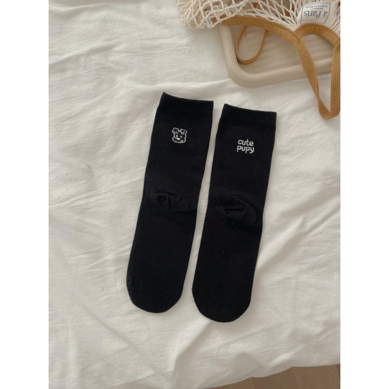 

The Embroidered Cartoon Dog with The Letters AB Has Asymmetrical Mid-calf Socks on Both Feet and Pairs of Socks on Top 1 pair