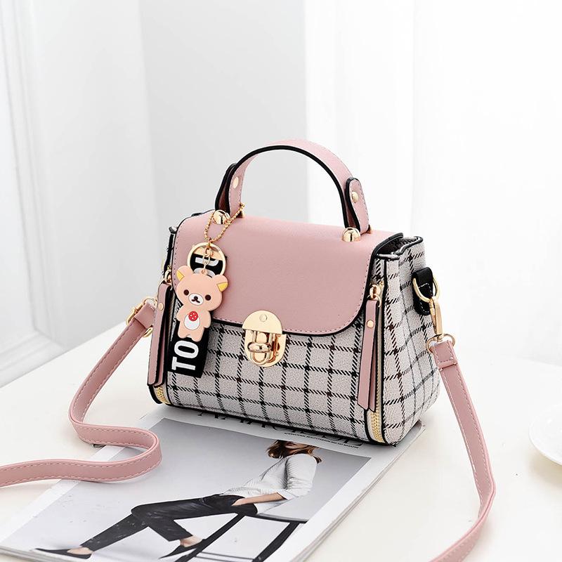 

Маленькая женская сумка в клетку с брелком розовый