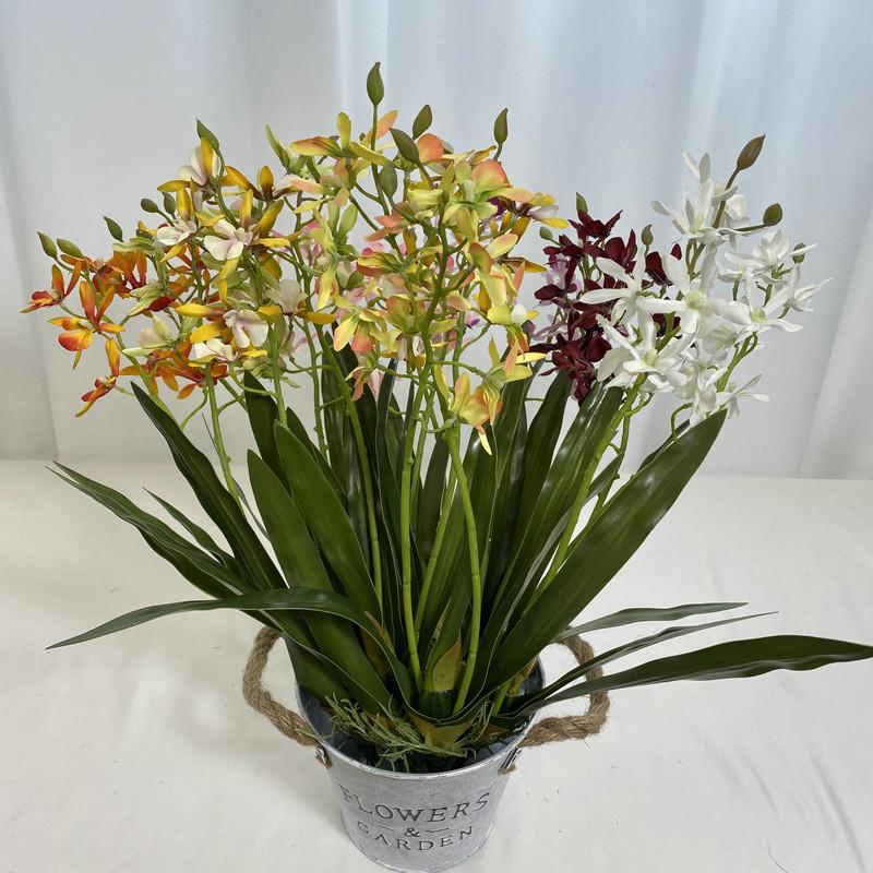Realistische Seiden-Dendrobium-Orchidee mit Blättern für Blumengesteck auf dem Esstisch