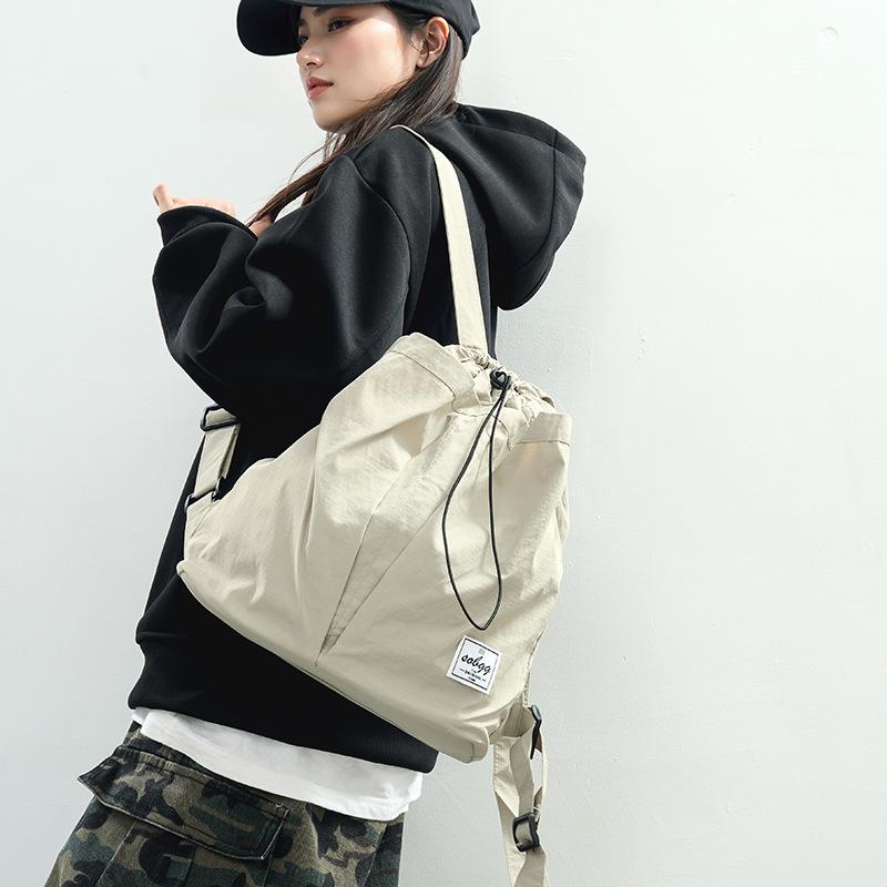 The new Hong Kong wind locomotive drawstring is simple andlarge-capacity leisure. Men and women have the same commuter backpack and student schoolbag.
