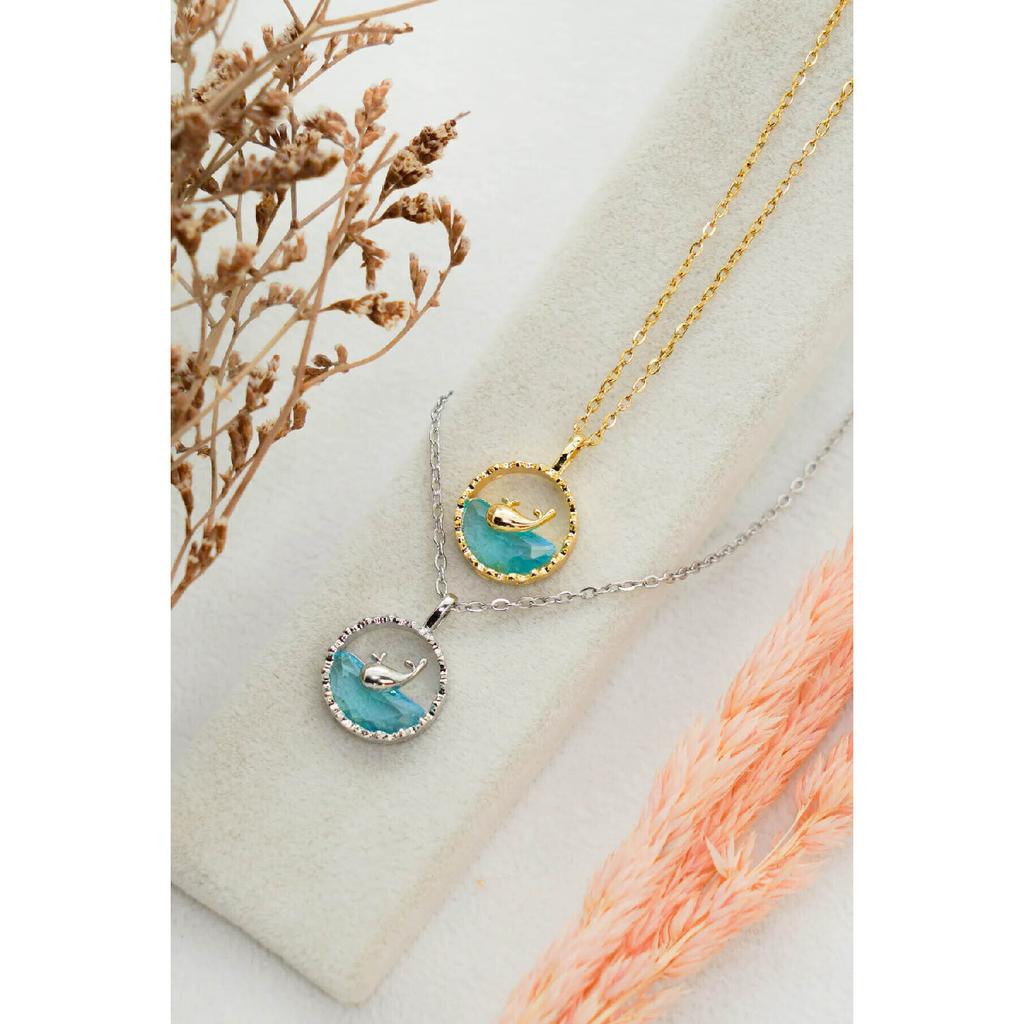 Anlauffarbene Halskette aus Stahl mit Walfisch-Motiv, Fisch schwimmt im blauen Wasser, Modell silberfarbene Halskette aus Stahl