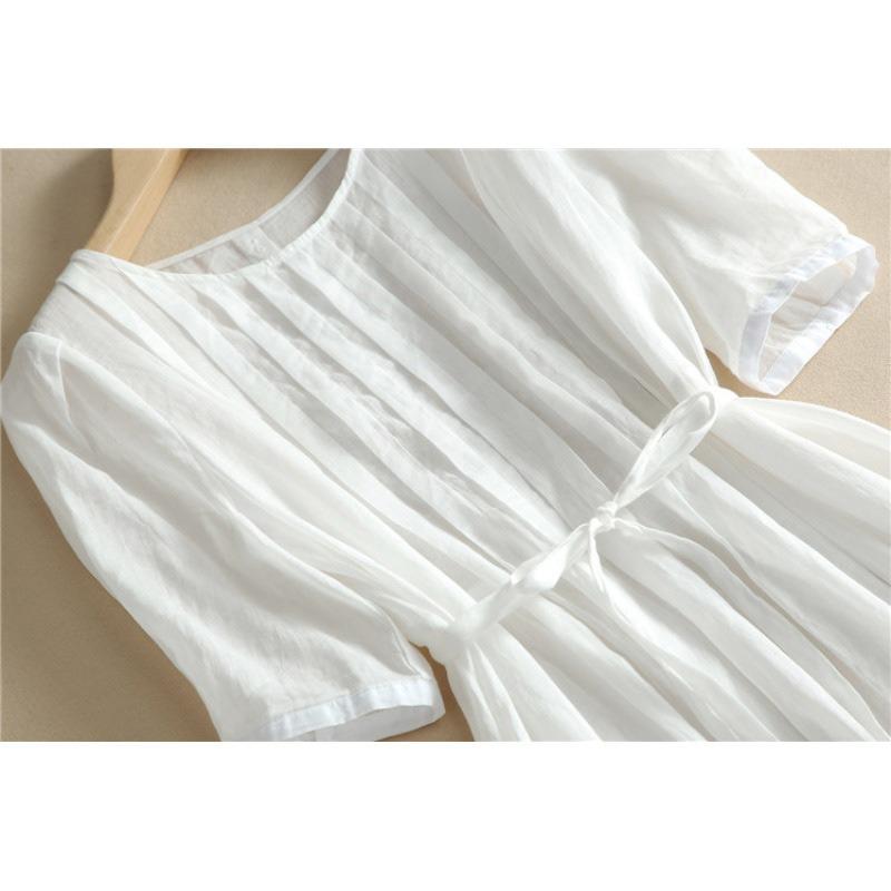 Eine Frau in einem weißen Kleid mit Schnürung und geraffter Taille