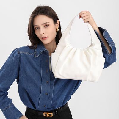 Eine kleine Hand mit einer plissierten Textur Cloud Bag Fashion Croissant Damentasche