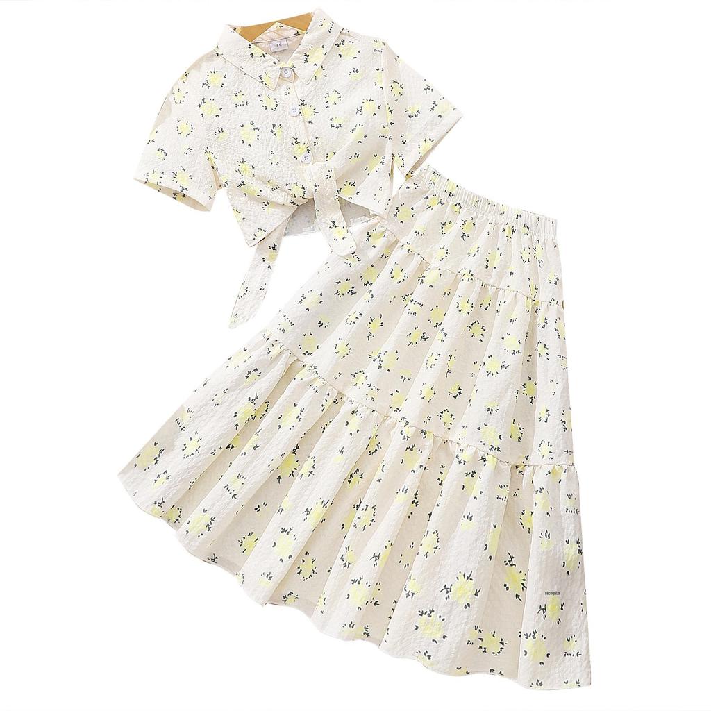 Flickors topp med blommigt slag och kjolset