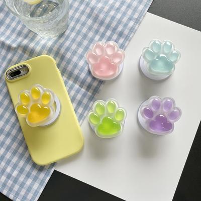 Kleurrijke, in het donker oplichtende telefoonhouder in de vorm van een kattenpoot met luchtkussen, magnetische, uitschuifbare standaard voor comfortabel tv-kijken op je bureau